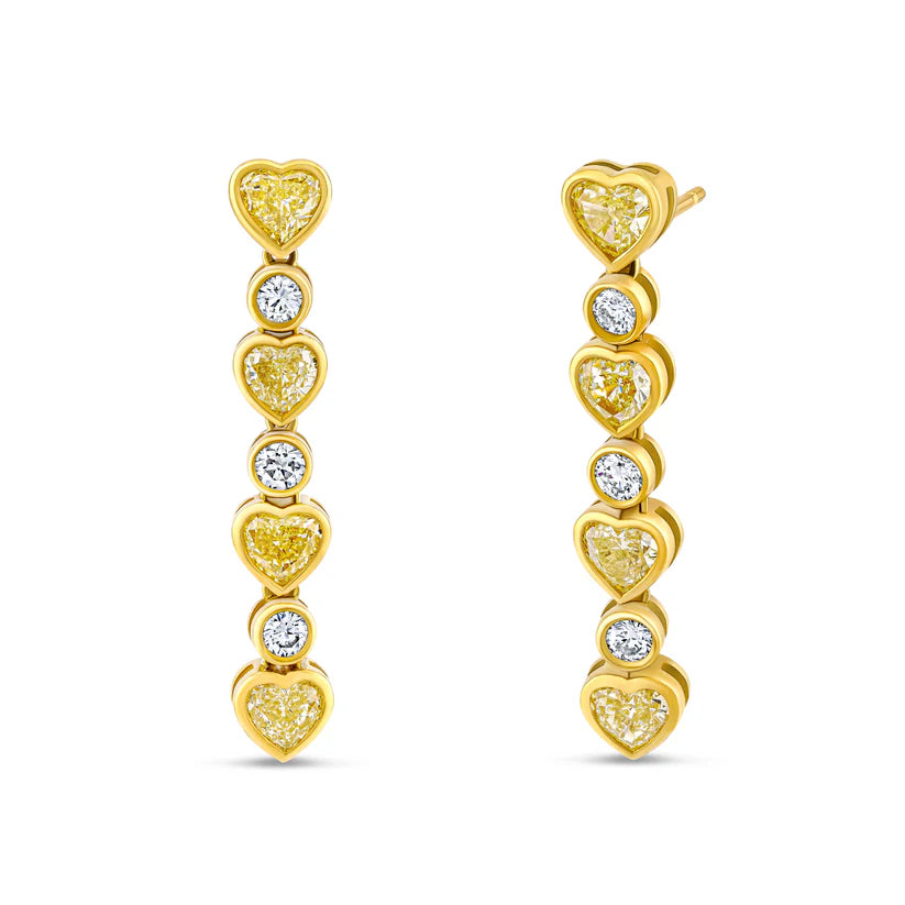 Gold heart-shaped earrings with embedded diamonds on a white background