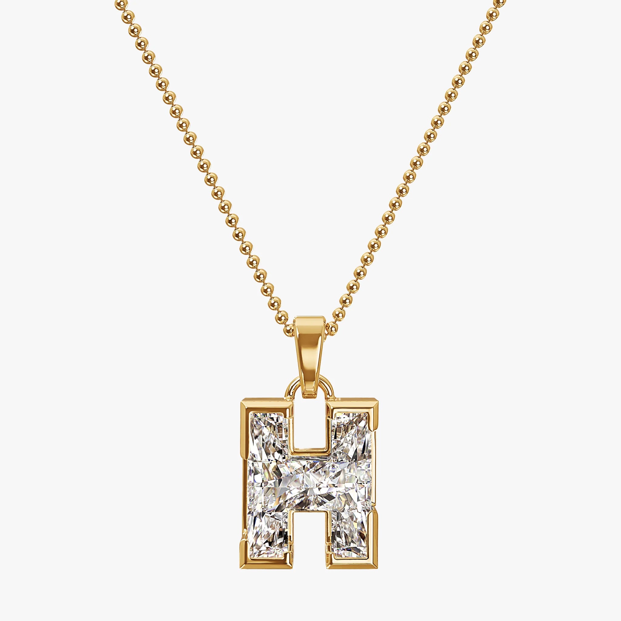 Gold necklace with a diamond-encrusted 'H' pendant on a white background