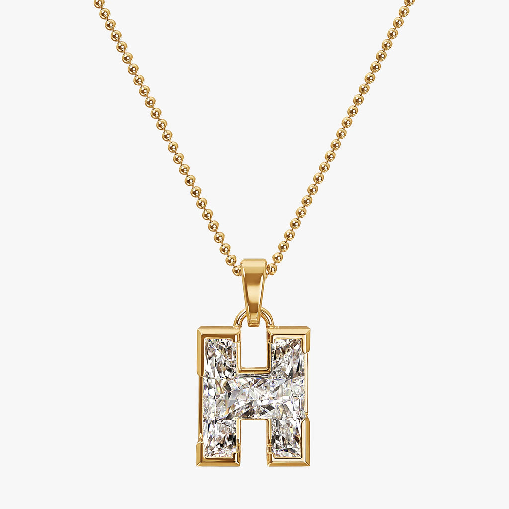 Gold necklace with a diamond-encrusted 'H' pendant on a white background